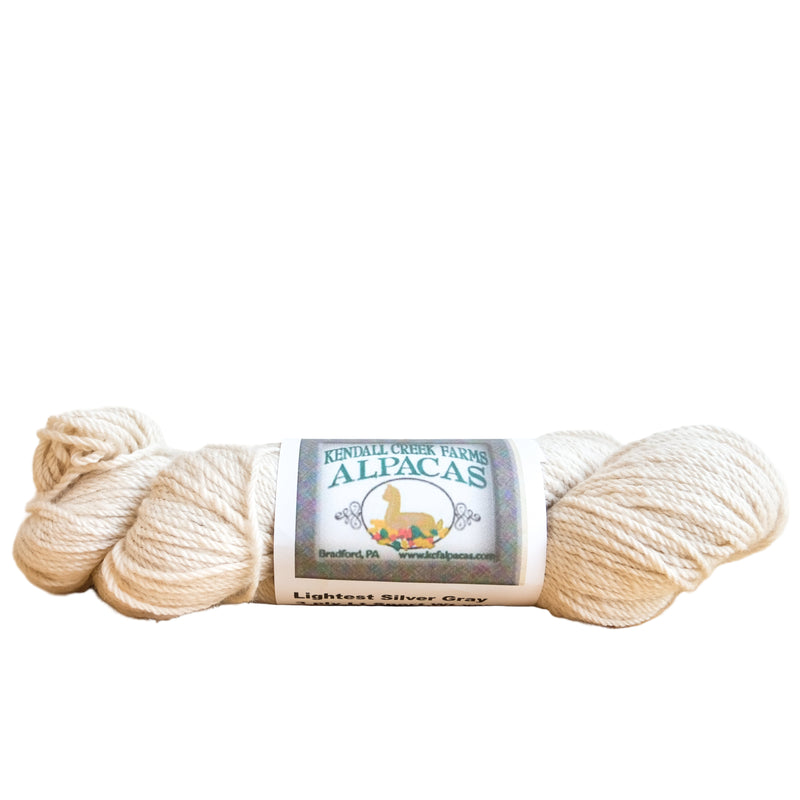 Ball of yarn with a label on a wooden surface and white paneled wall background
