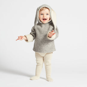 Child wearing a gray hooded outfit with bunny ears on a white background