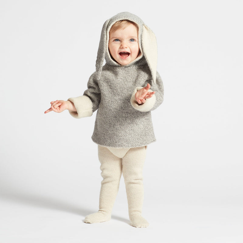 Child wearing a gray hooded outfit with bunny ears on a white background