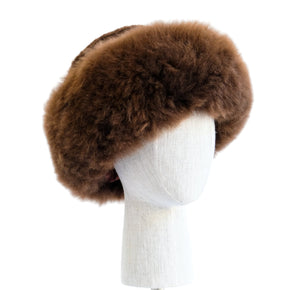 Premium Baby Alpaca Fur Hat. A brown Premium Baby Alpaca Fur Hat on a mannequin head against a white paneled background.