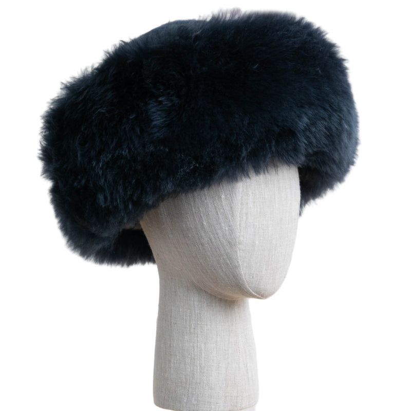 Premium Baby Alpaca Fur Hat. A bluish charcoal Premium Baby Alpaca Fur Hat on a mannequin head against a white paneled background.