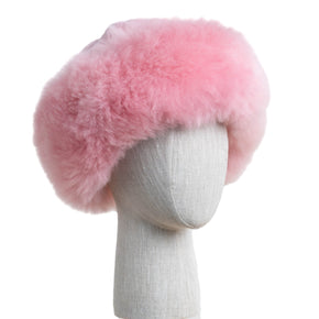 Premium Baby Alpaca Fur Hat. A pink Premium Baby Alpaca Fur Hat on a mannequin head against a white paneled background.