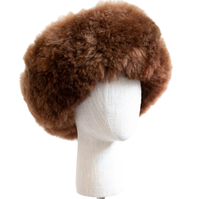Premium Baby Alpaca Fur Hat. A brown Premium Baby Alpaca Fur Hat on a mannequin head against a white paneled background.
