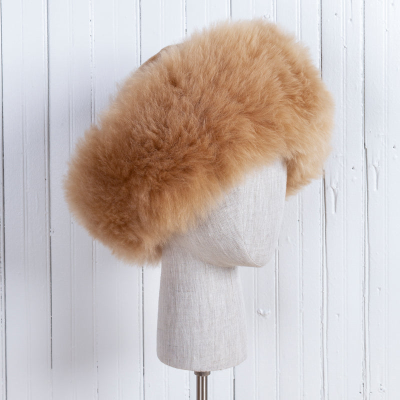 Premium Baby Alpaca Fur Hat. A light brown/fawn Premium Baby Alpaca Fur Hat on a mannequin head against a white paneled background.