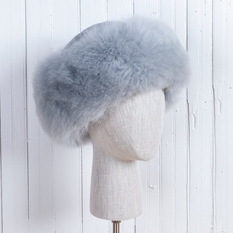 Premium Baby Alpaca Fur Hat. A light grey Premium Baby Alpaca Fur Hat on a mannequin head against a white paneled background.