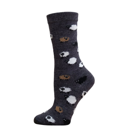 A pair of alpaca wool socks with a sheep pattern, displayed on a wooden platform.